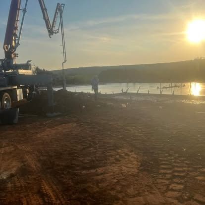 A concrete pump is being used to pour concrete into a lake.