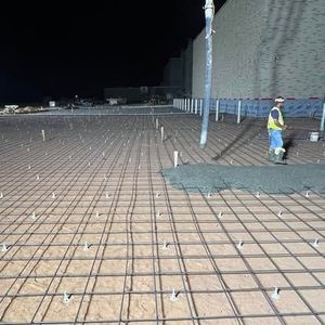 A man is standing on a concrete floor at night.