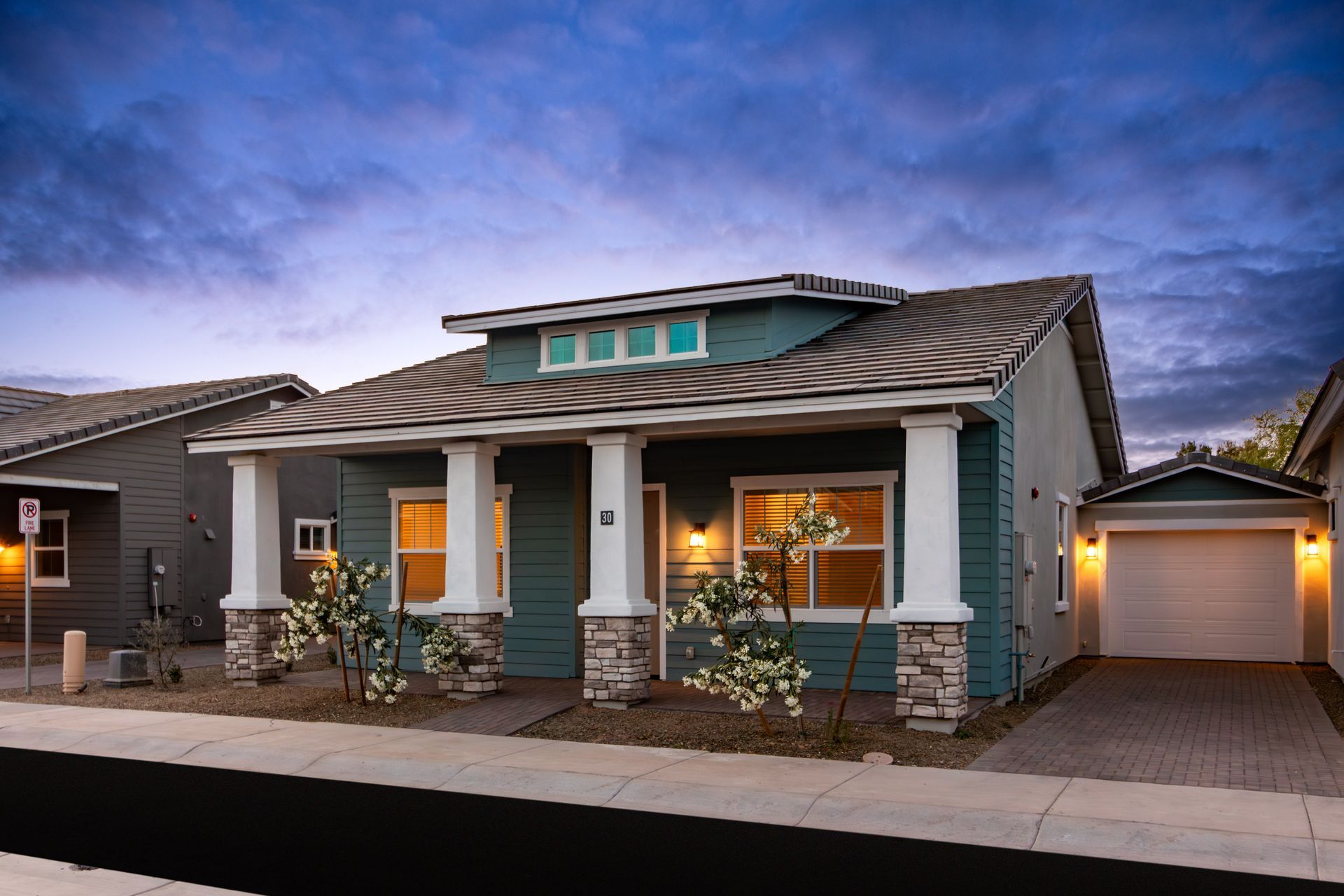 A blue house with a porch and a garage