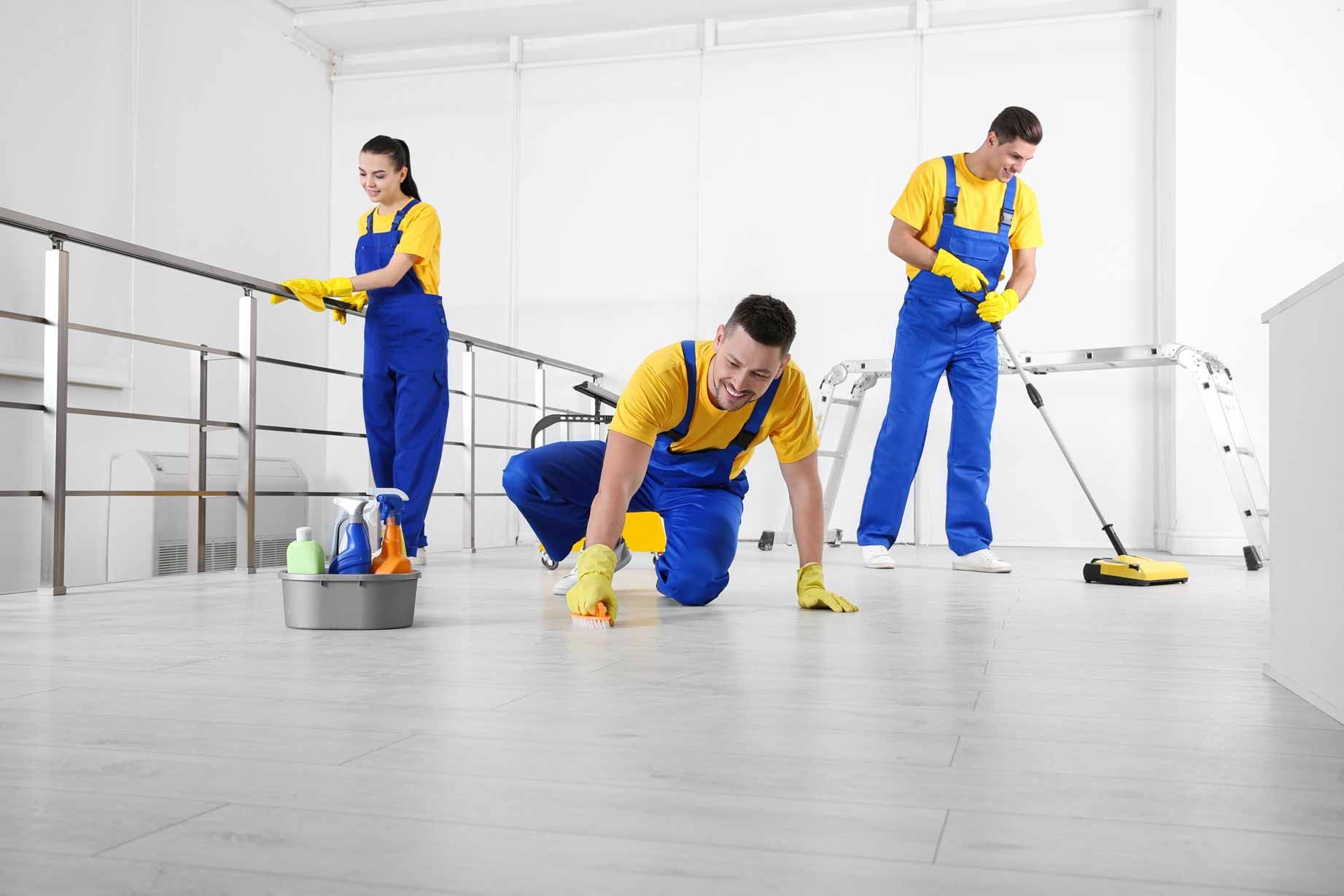 Janitors cleaning a bright room with mops, bucket, and cleaning supplies