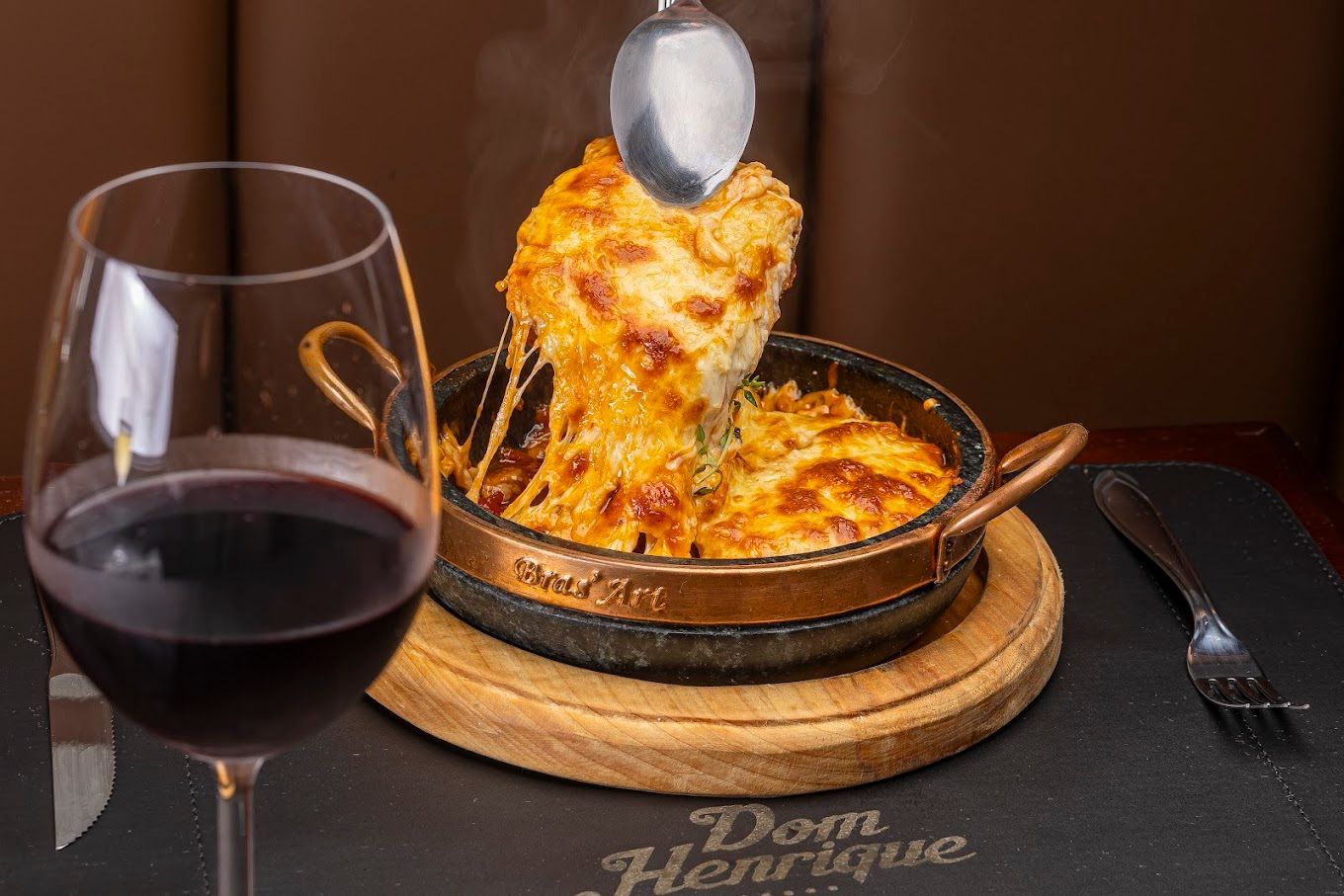 Prato de comida do restaurante Don Henrique, com taça de vinho