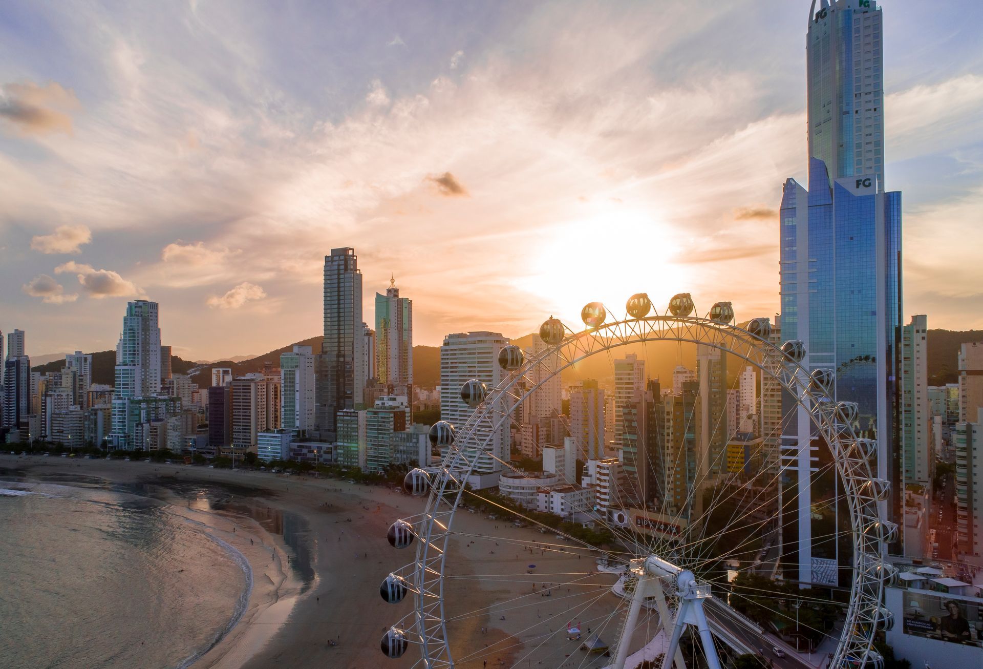 Pôr do sol em Balneário Camboriú, com a FG Big Wheel à direita e a orla ao fundo.