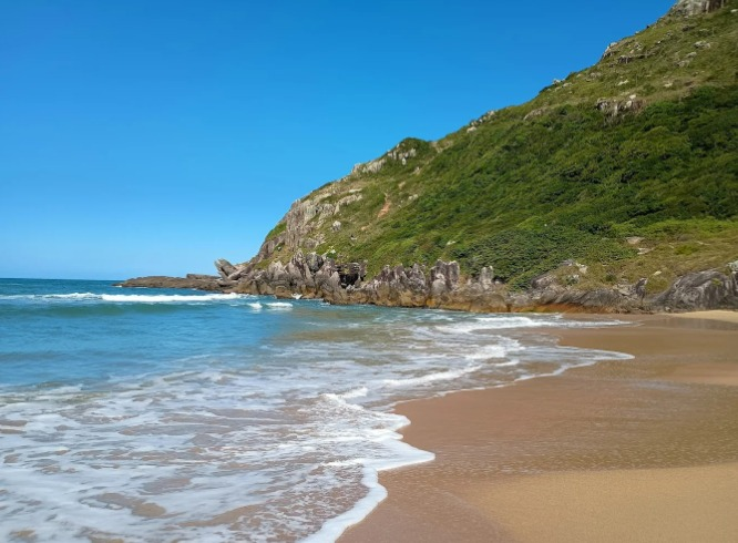 Vista da Praia da Lagoinha do Leste cercada por montanhas e vegetação preservada