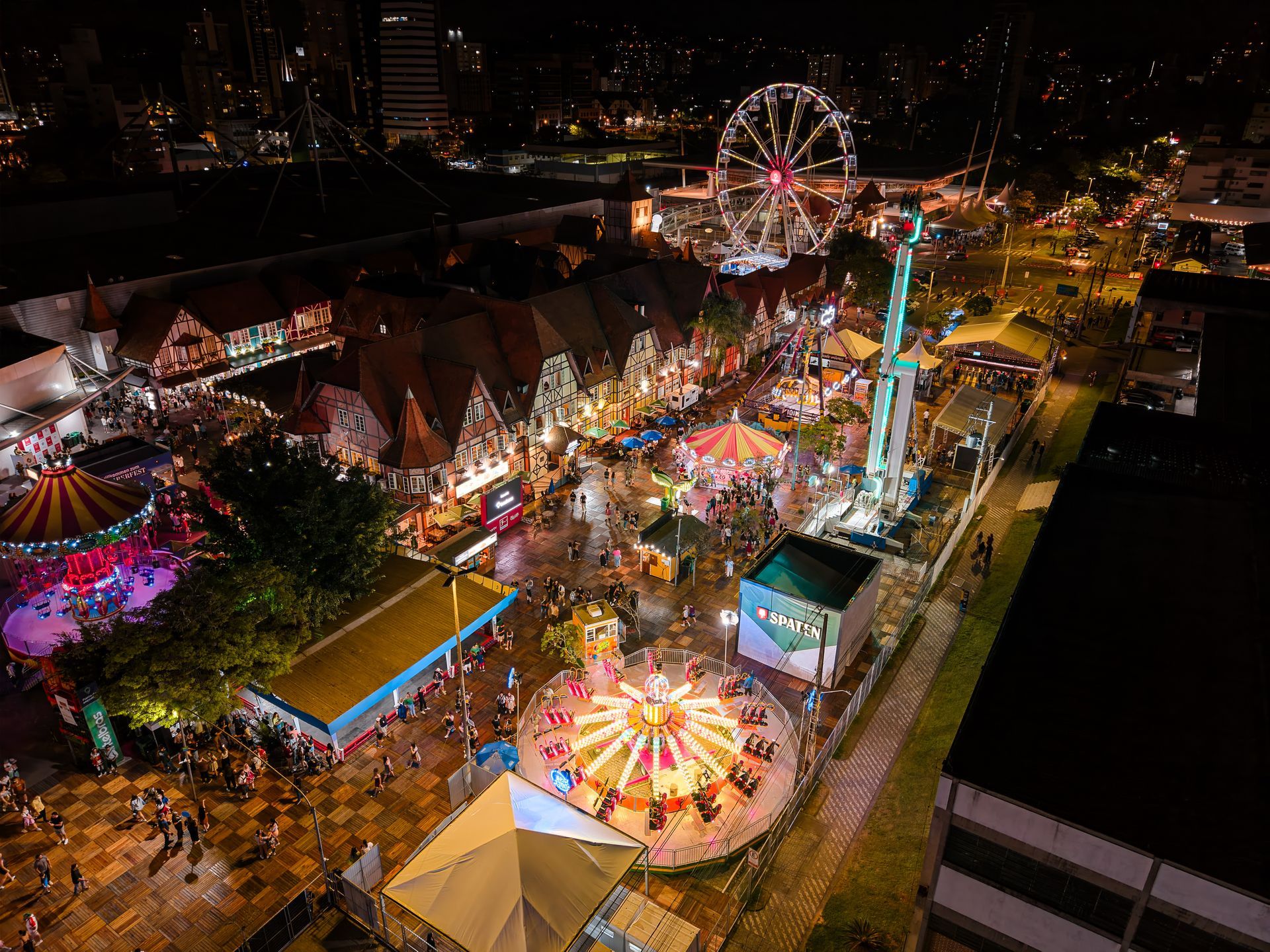 Vista aérea noturna do Parque, com roda-gigante e atrações da Oktoberfest