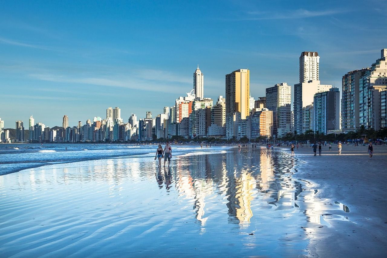 Prédios refletidos na areia da Praia Central de Balneário Camboriú.