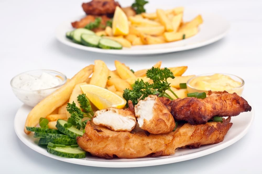 Two Plates of Fish and French Fries on A Table — Brews & Bites Beachside Cafe in Meikleville Hill, QLD