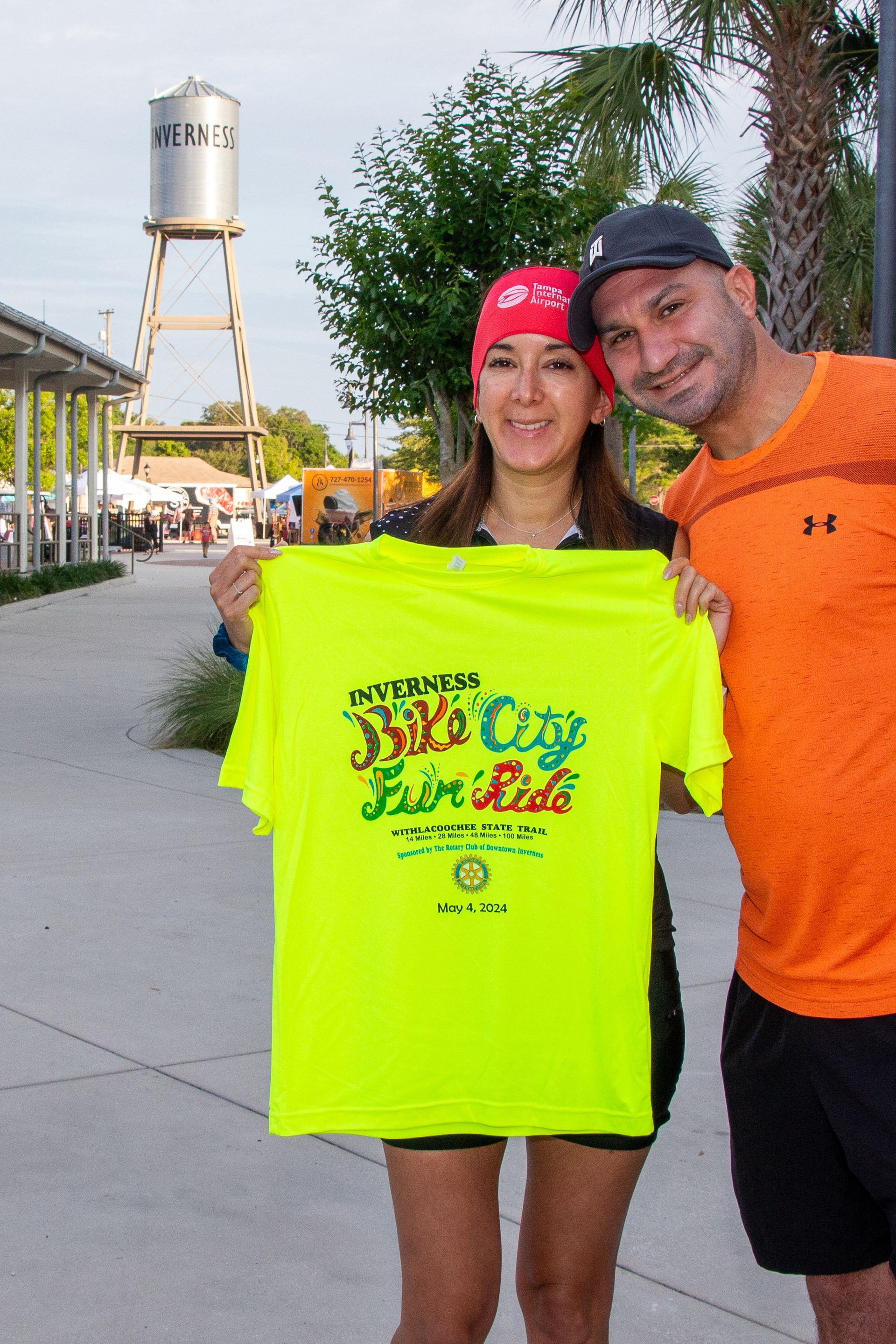 A man and a woman are holding a yellow shirt that says fair ride