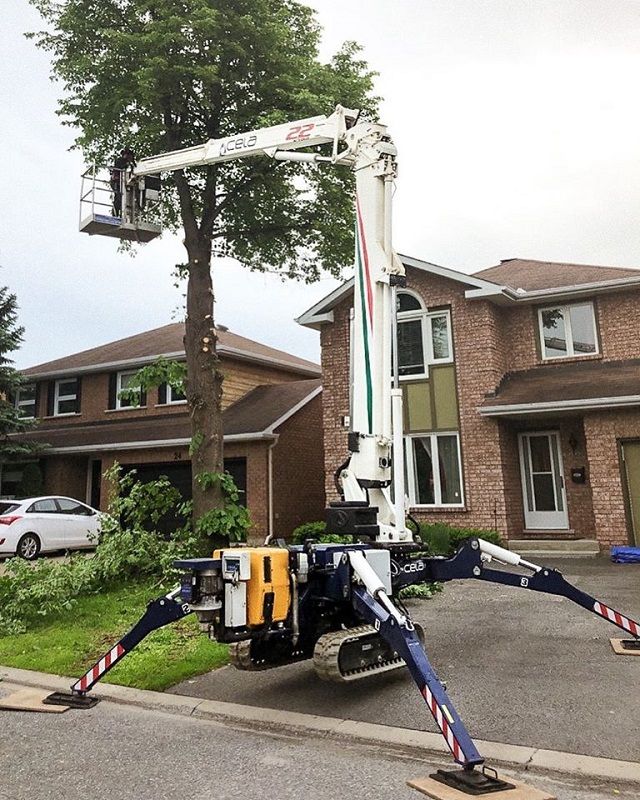 A crane is sitting in front of a brick house