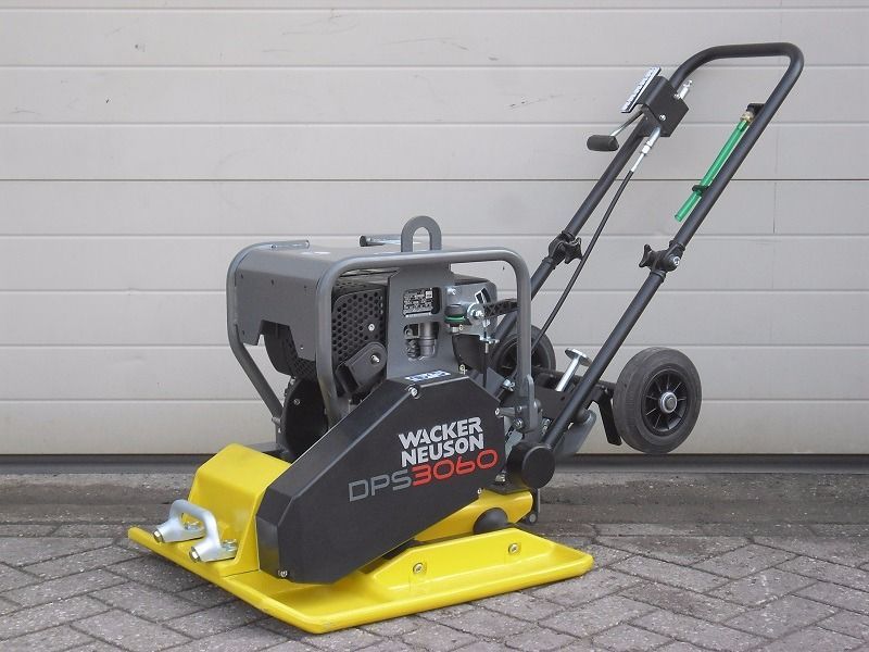 A wacker neuson dps 3060 compactor is sitting on a brick sidewalk.
