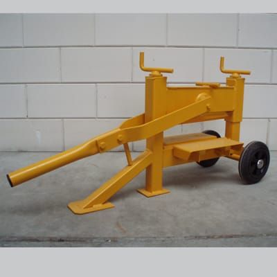 A yellow machine with wheels is sitting in front of a white brick wall