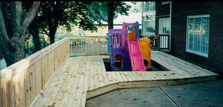A wooden deck with a slide in the middle of it