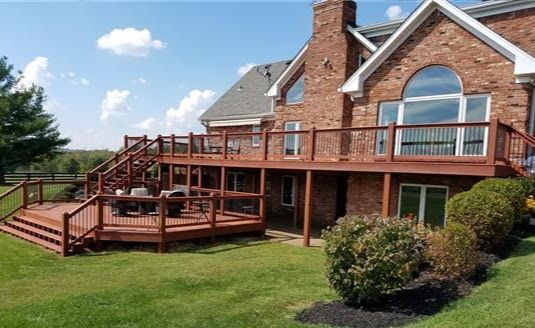 A large brick house with a large wooden deck in front of it