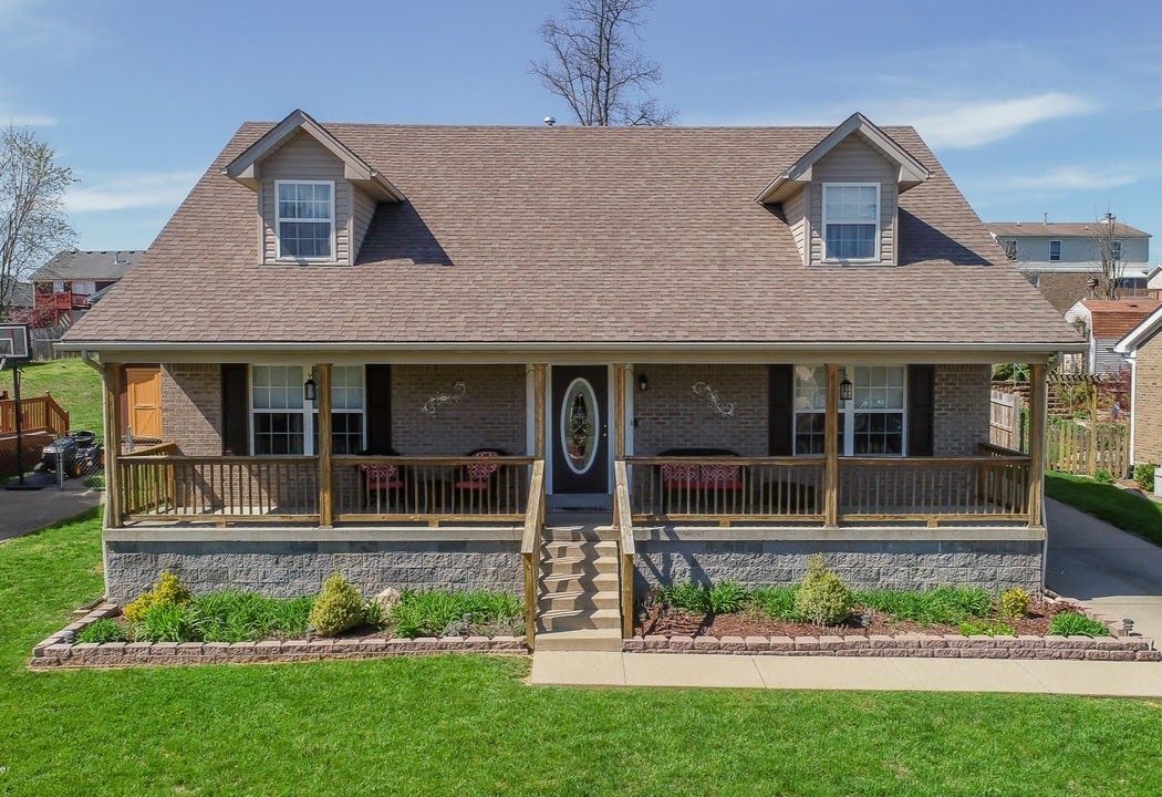 A large house with a large porch and a lot of windows.
