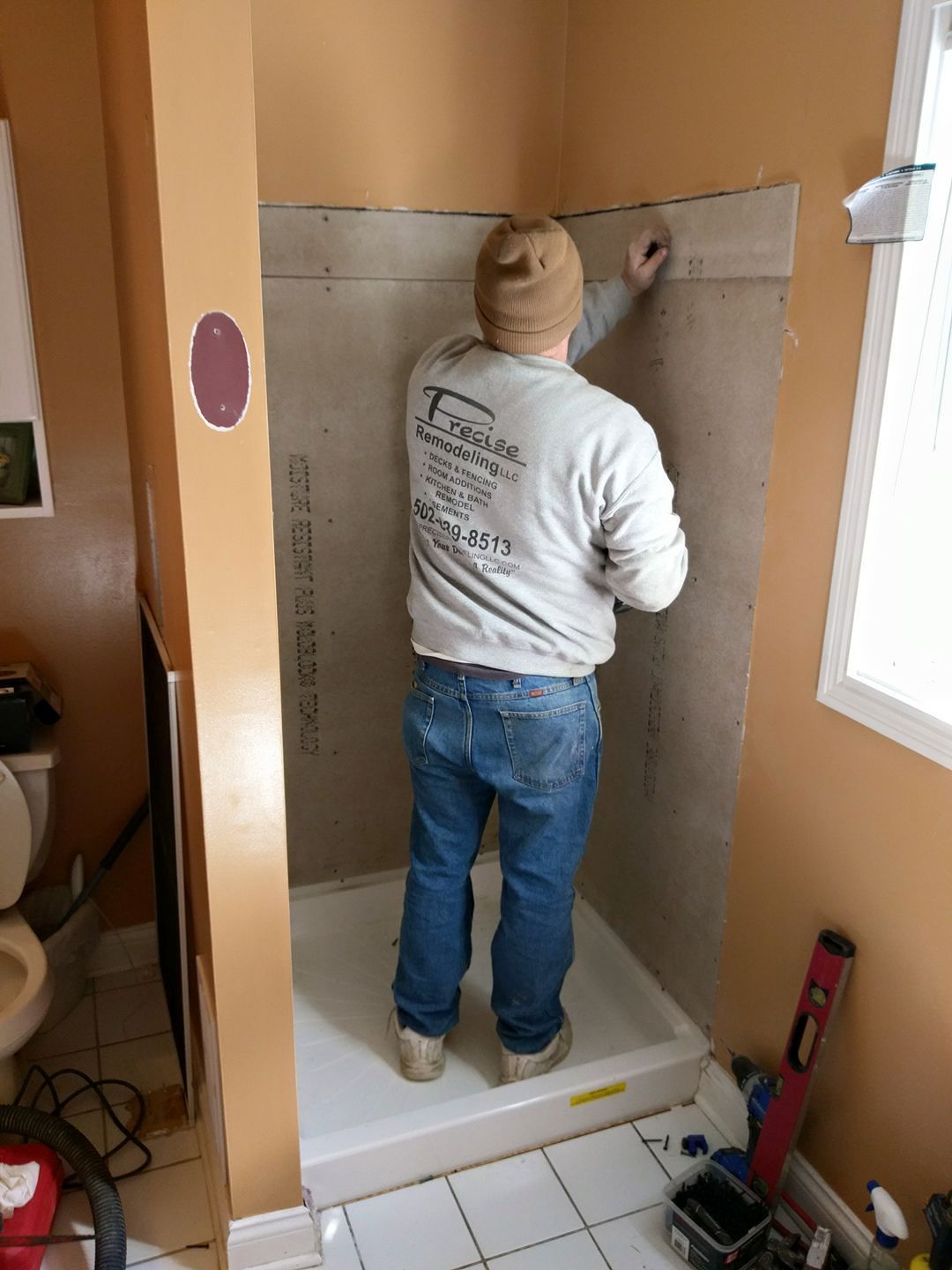 A man is working on a shower in a bathroom.