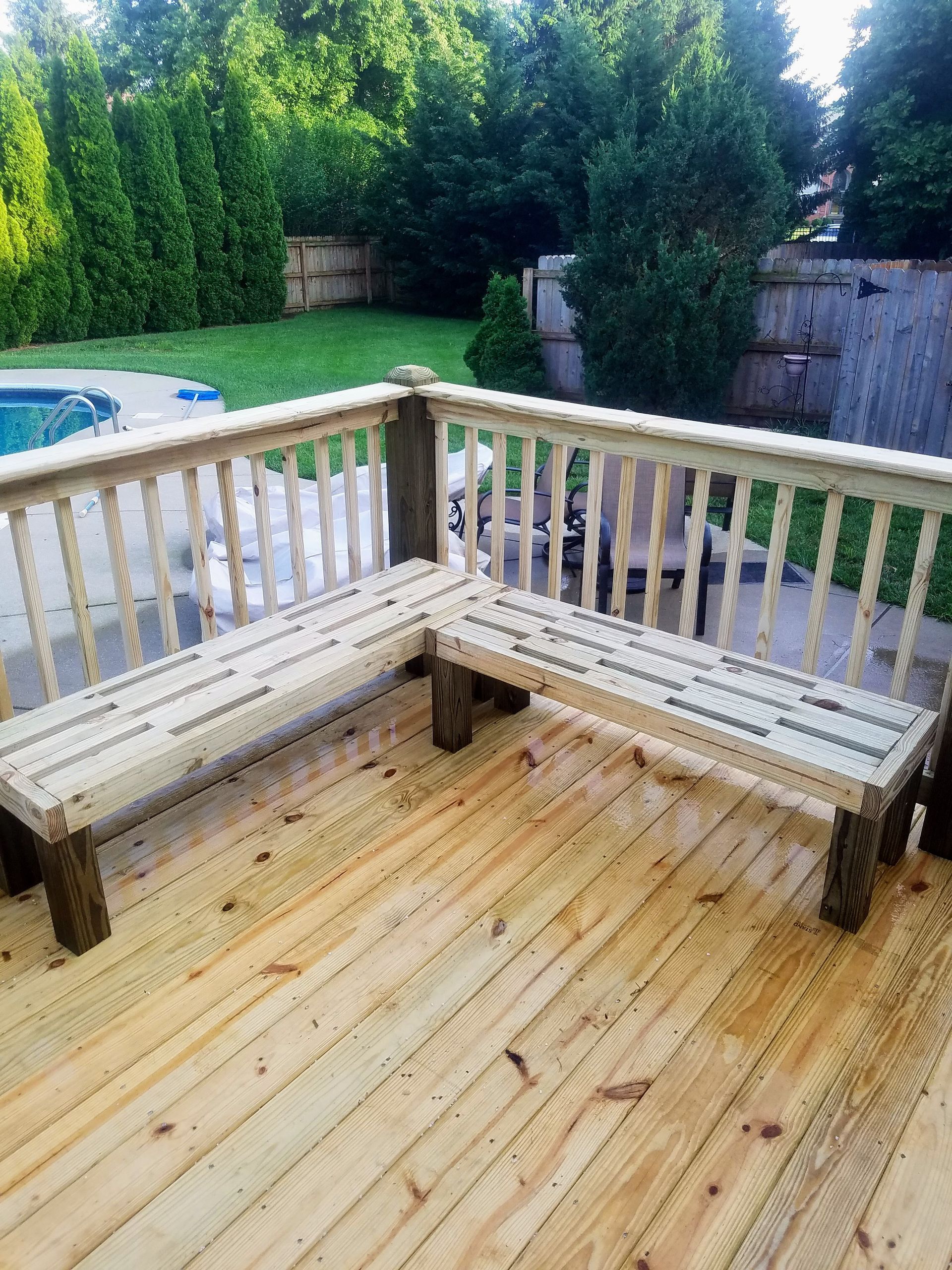 A wooden bench is sitting on top of a wooden deck.