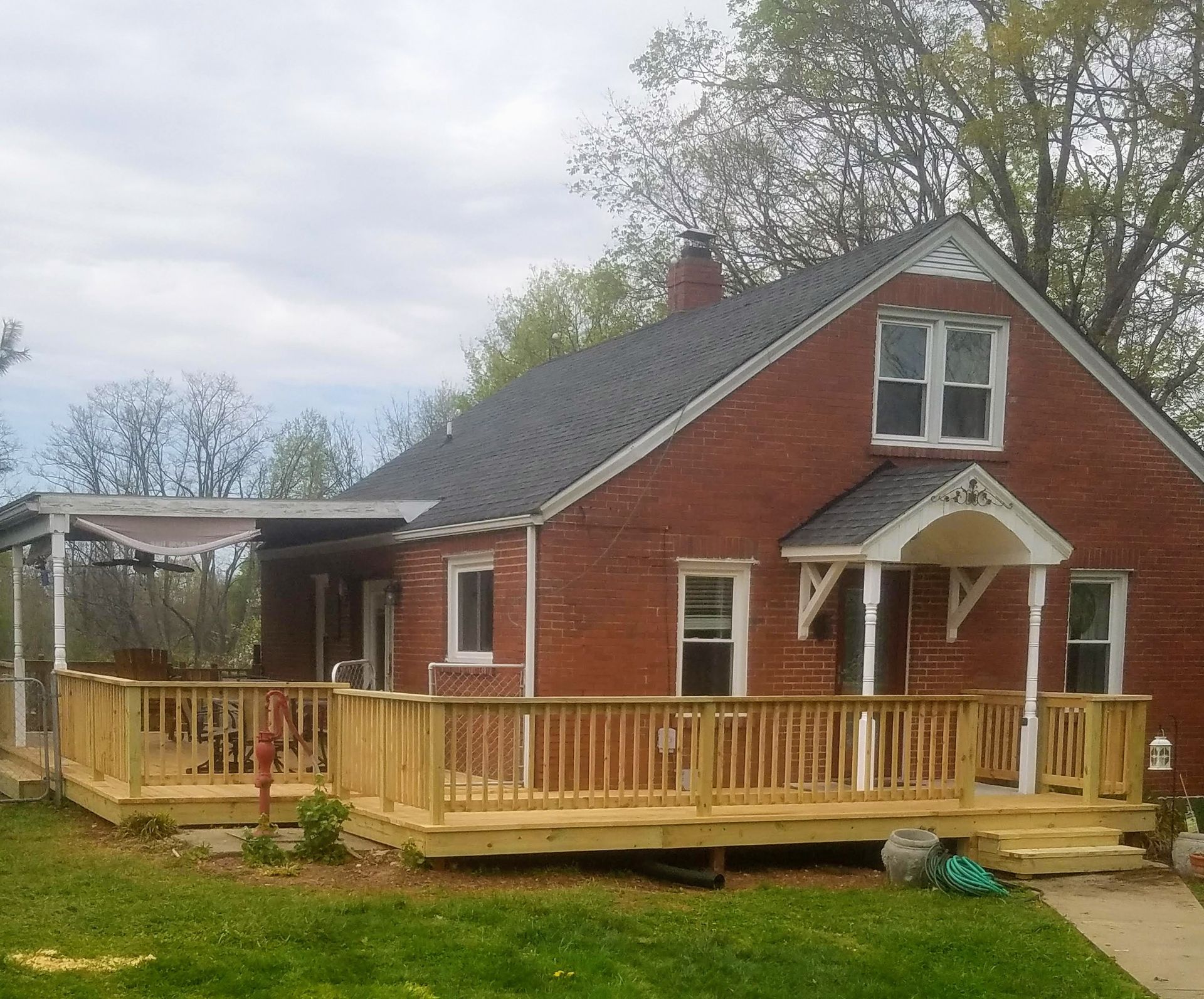 A brick house with a wooden deck in front of it
