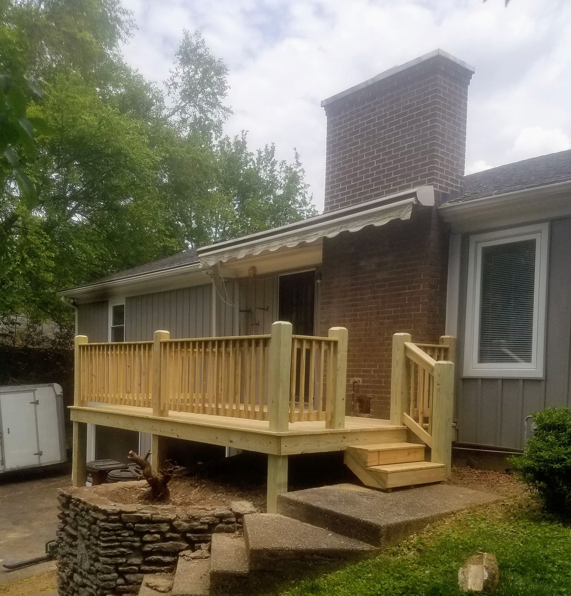 A brick house with a wooden deck in front of it