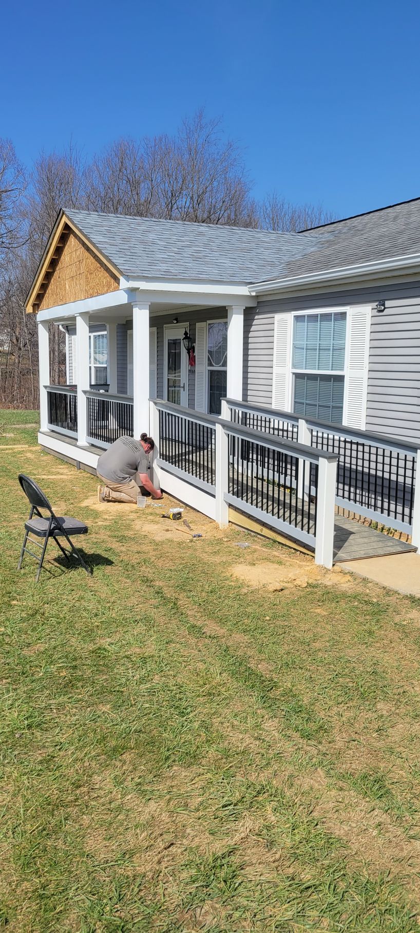 A man is laying on the grass in front of a house.