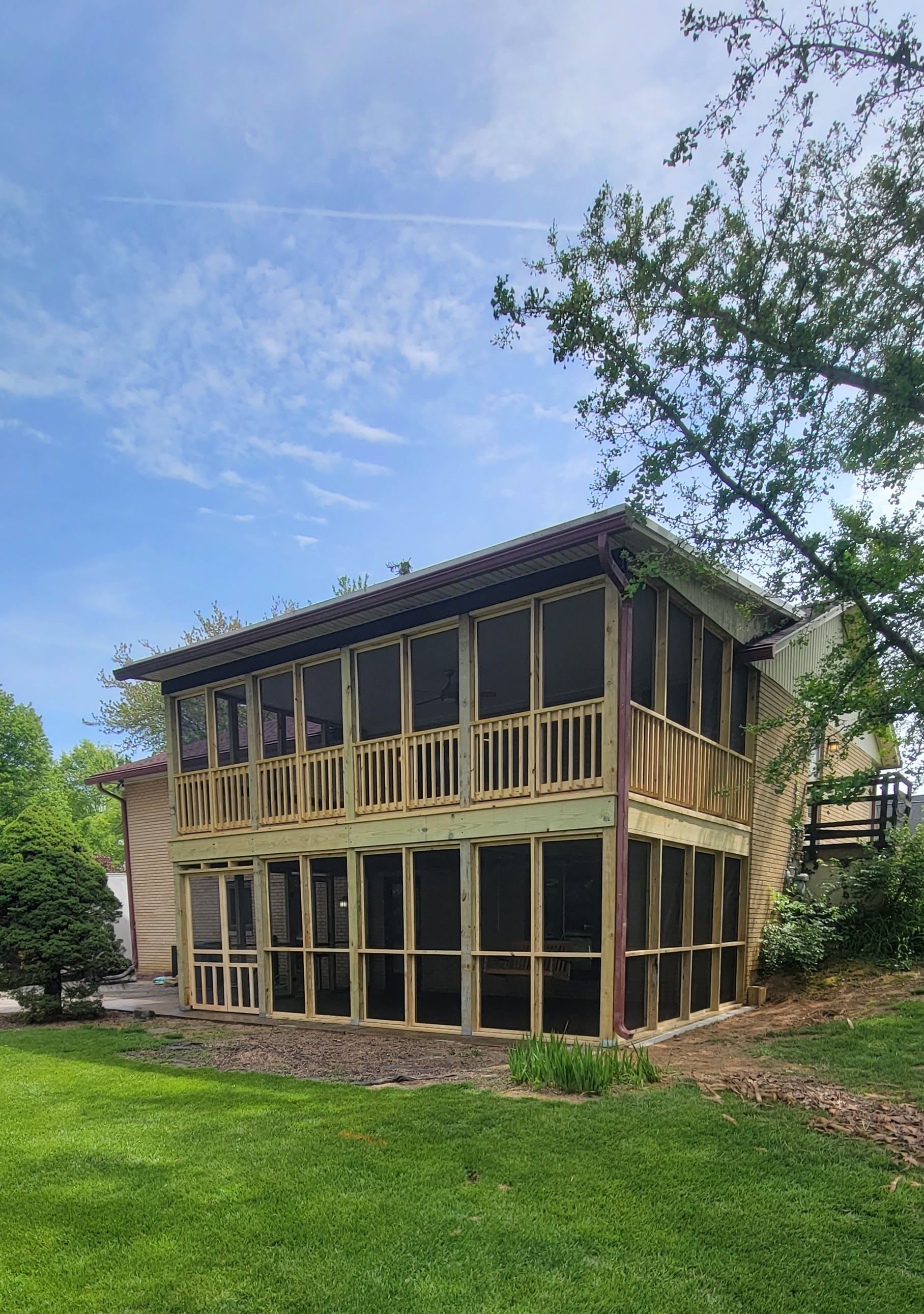 A screened in porch is being built on the side of a house.