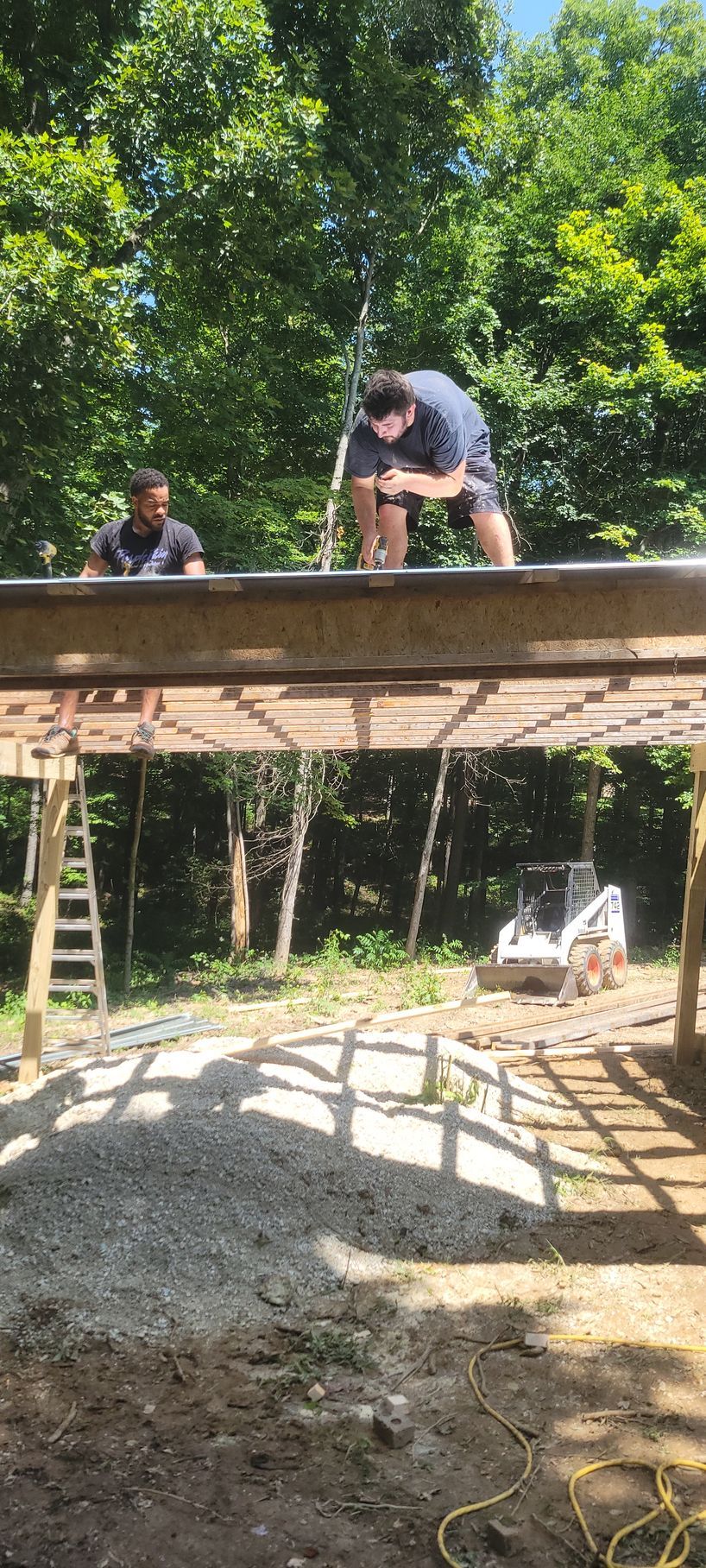 Two men are working on a wooden deck.