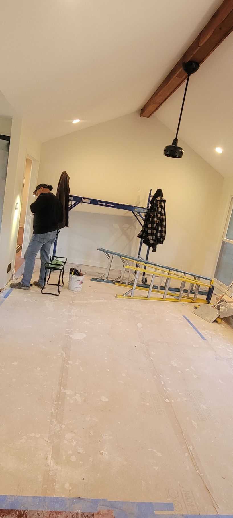 A man is standing on a ladder in a room.