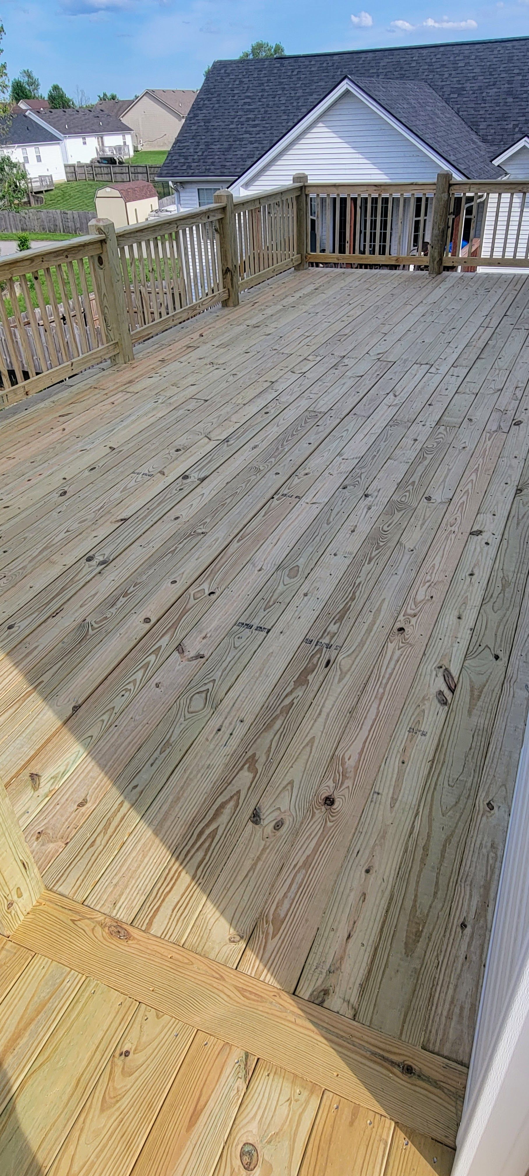 A wooden deck is being built in front of a house.