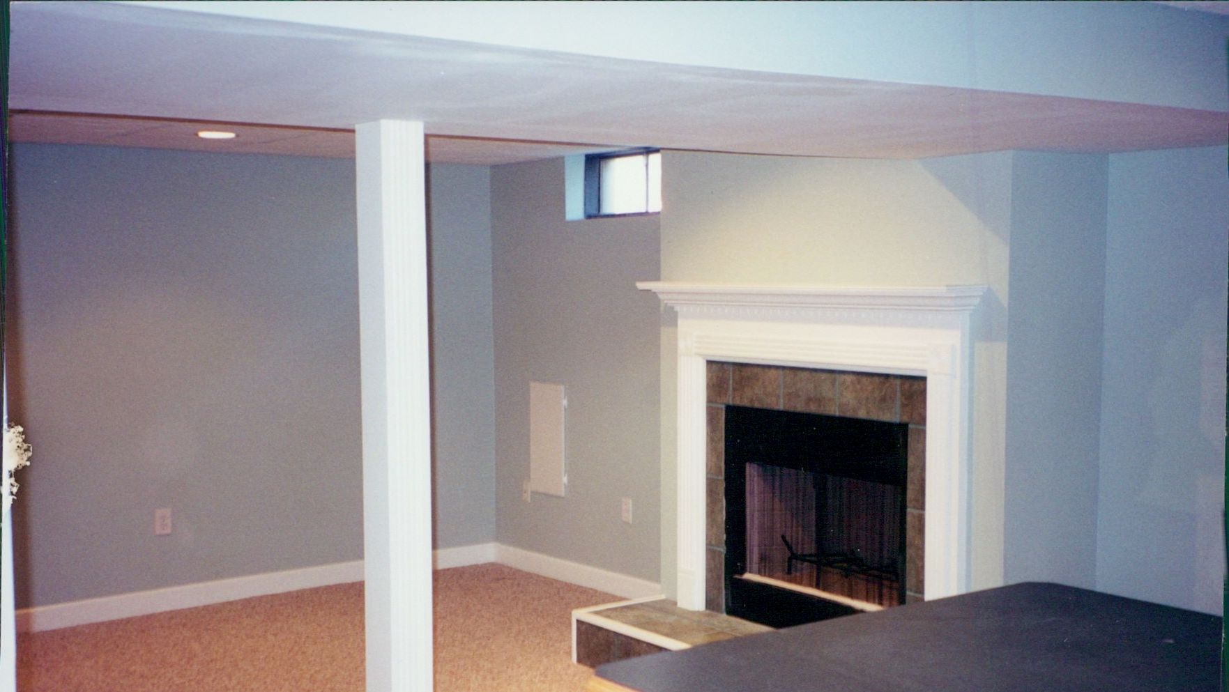 A basement with a fireplace and a window
