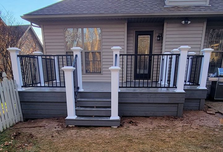 A house with a deck and stairs in front of it.