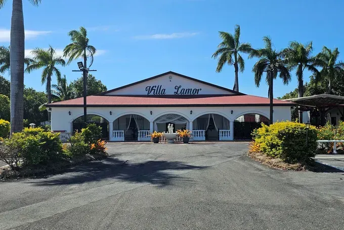 Villa Lazar Building Entrance With Archways and Palm Trees — Villa Lamor in Balberra, QLD