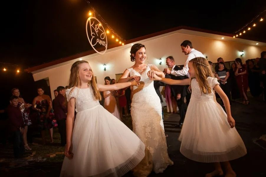 Bride Dances With Flower Girls at an Outdoor Wedding Reception Under String Lights — Villa Lamor in Balberra, QLD