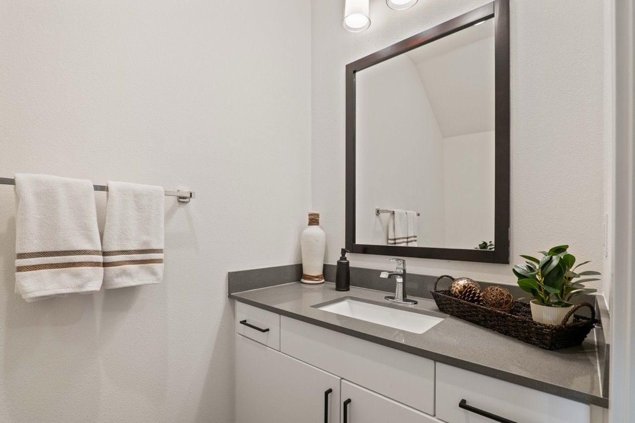 Bathroom vanity with sink, mirror, and towel rack.