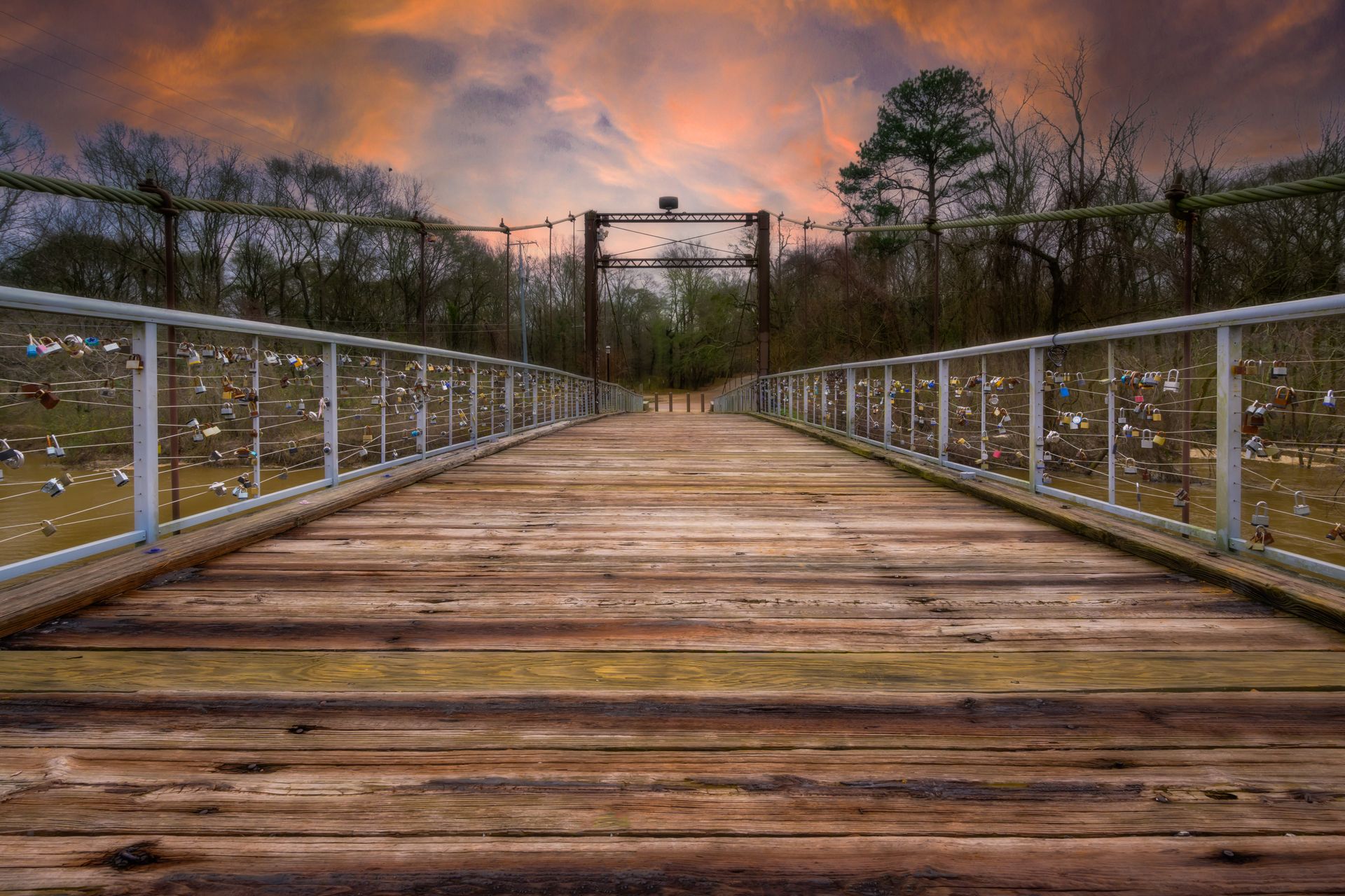 a wooden bridge with a sunset in the background .
