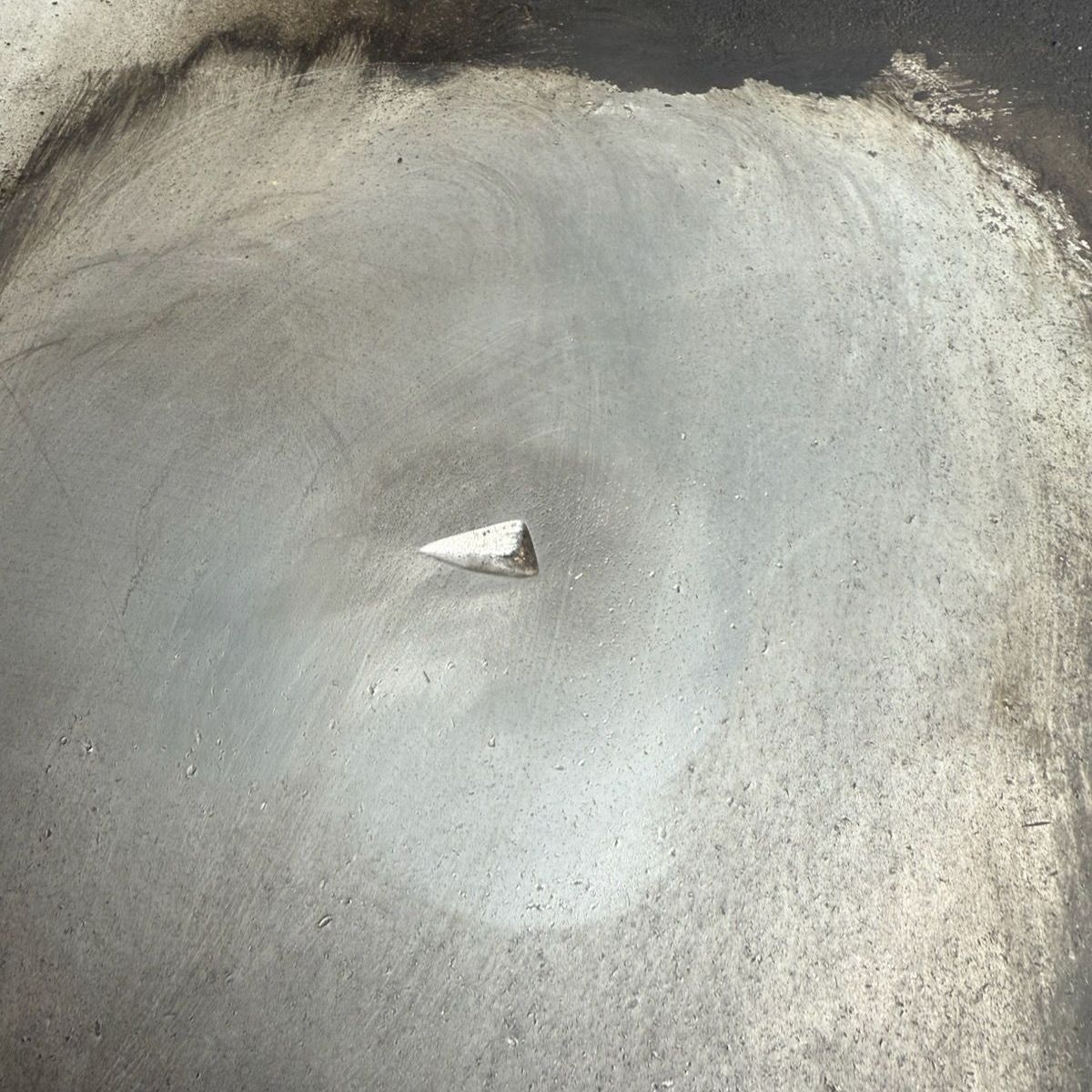 A small rock is sitting in the middle of a pool of water.