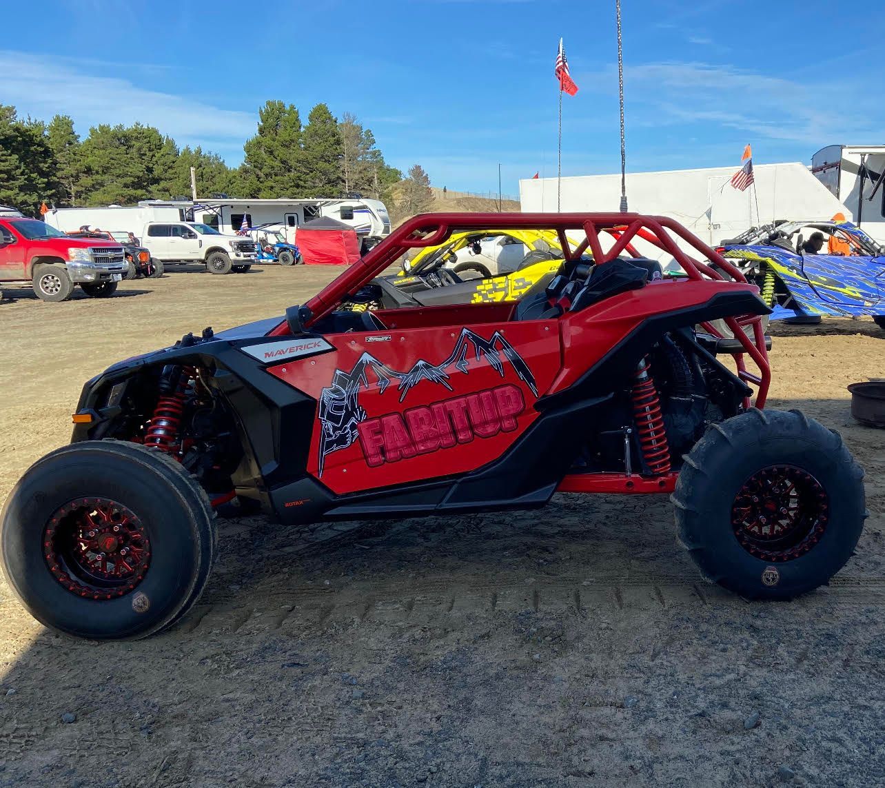 A red atv is parked in a dirt field.
