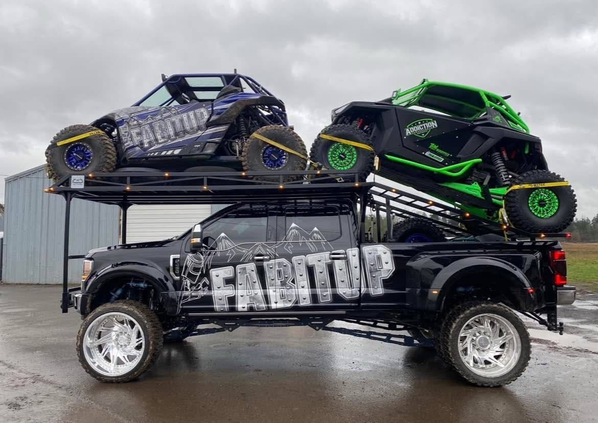 Two atvs are sitting on top of a truck.