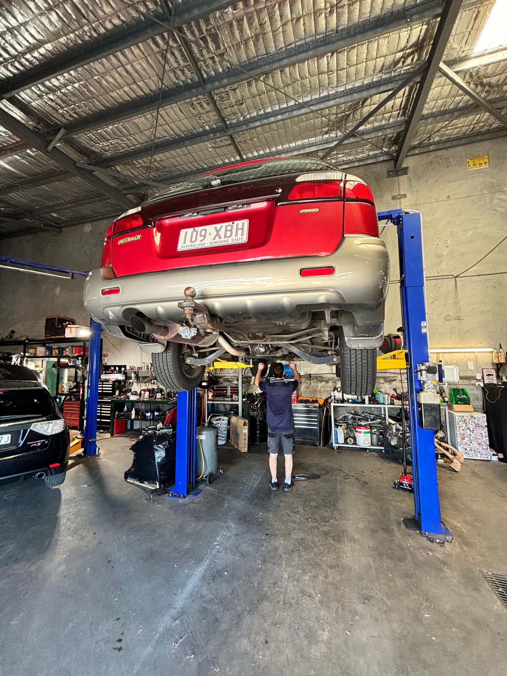 A Man Is Fixing A Brake Disc On A Car — Subi Care Mechanical In South Murwillumbah, NSW