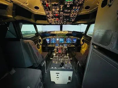 Cockpit interior: flight instruments, controls, pilot seats. Simulated runway view through the windshield.