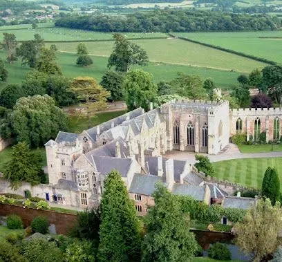 Stone abbey complex in green landscape.