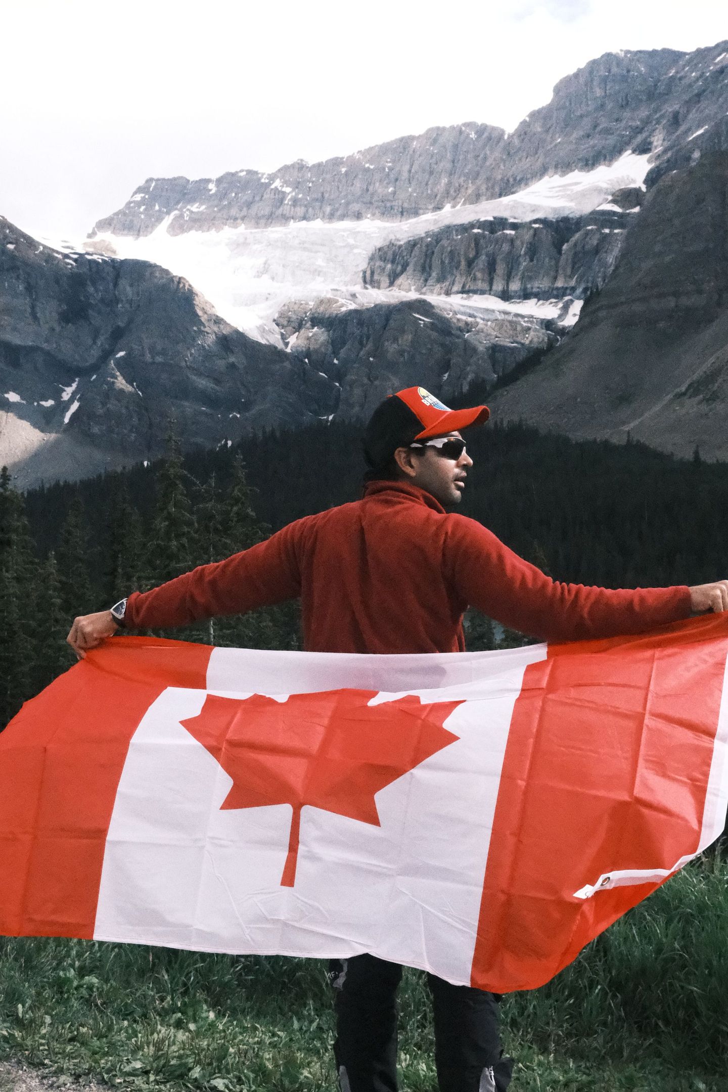 Guest celebrating with Canadian flag at Crowfoot Glacier Icefield Parkway, Banff Bear Travel day tour from Calgary
