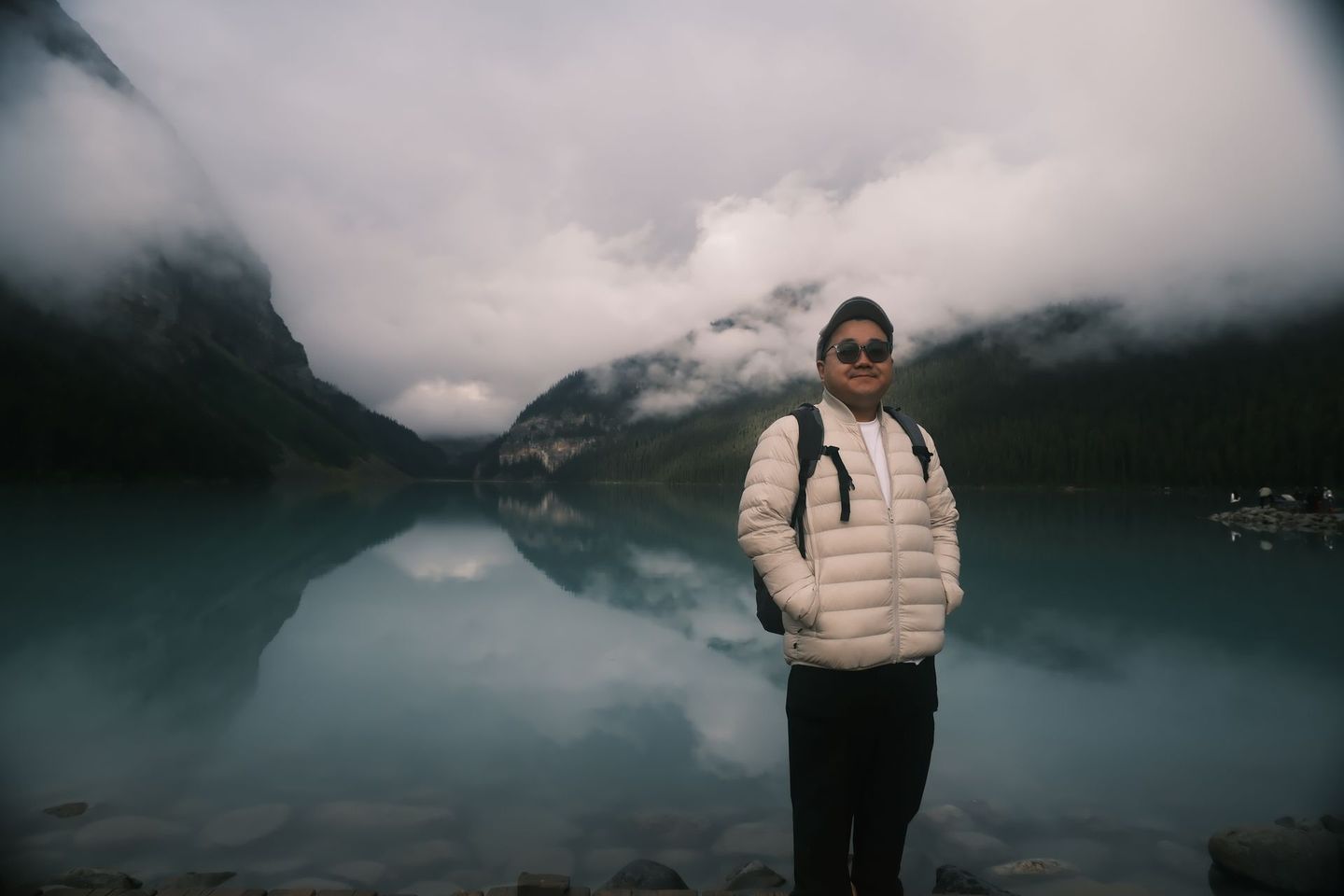 Solo traveller at Lake Louise on a moody overcast day, Banff Bear Travel all-season Banff tours 