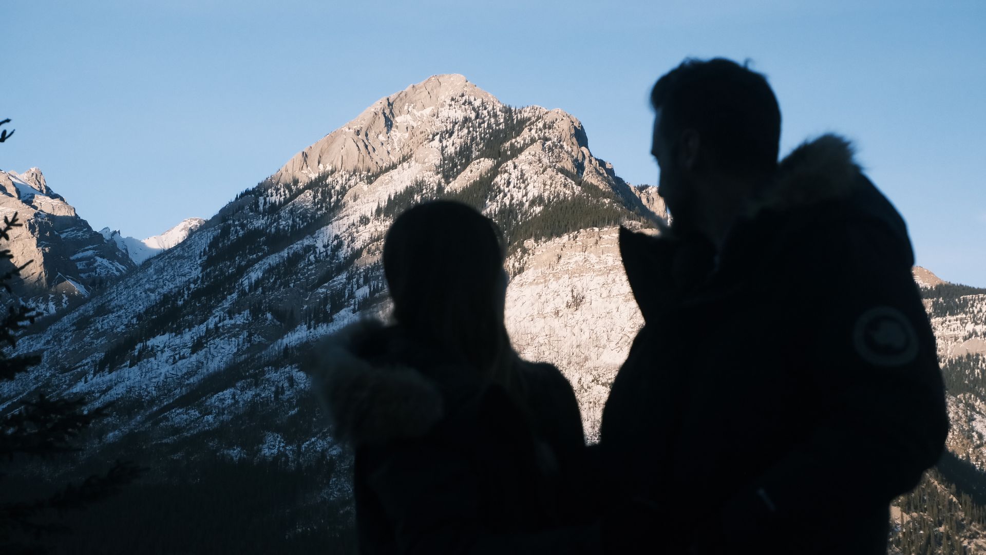 Couple enjoying the serene view of Lake Minnewanka, perfect photography-focused tour for solo travelers and couples in Banff National Park