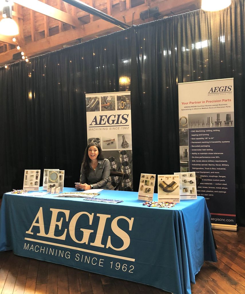 A woman sits at a table with aegis written on it