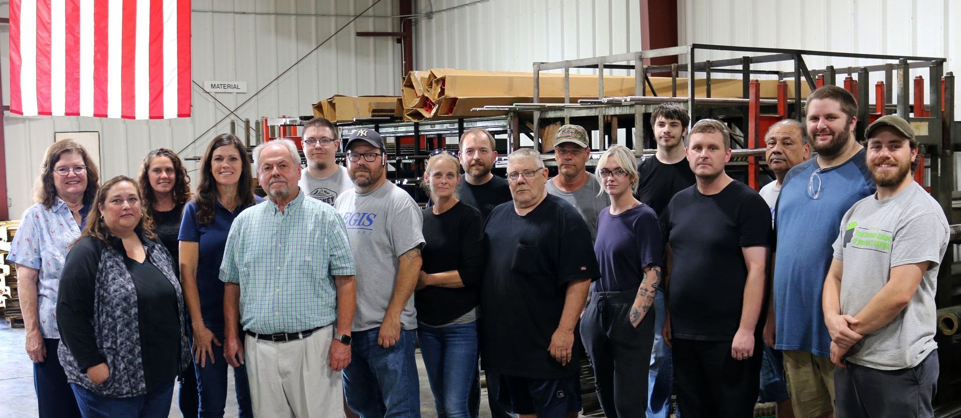 A group of people are posing for a picture in a warehouse.