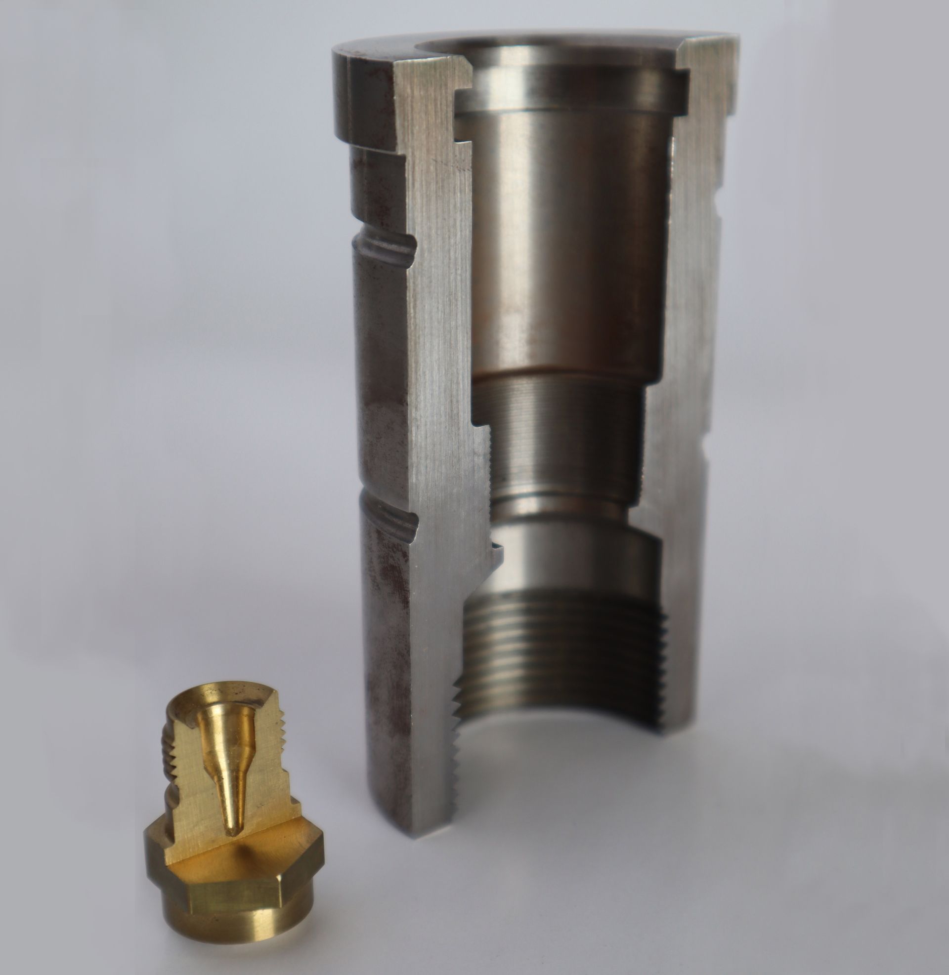 A metal cylinder with a brass fitting next to it