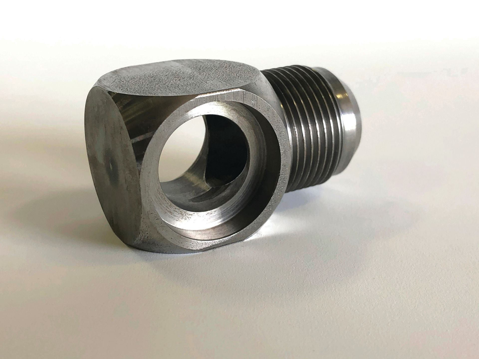 A close up of a metal object with a hole in the middle on a white surface.