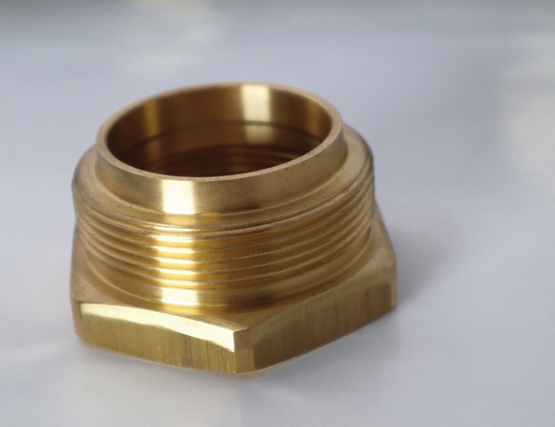 A close up of a brass fitting on a white surface