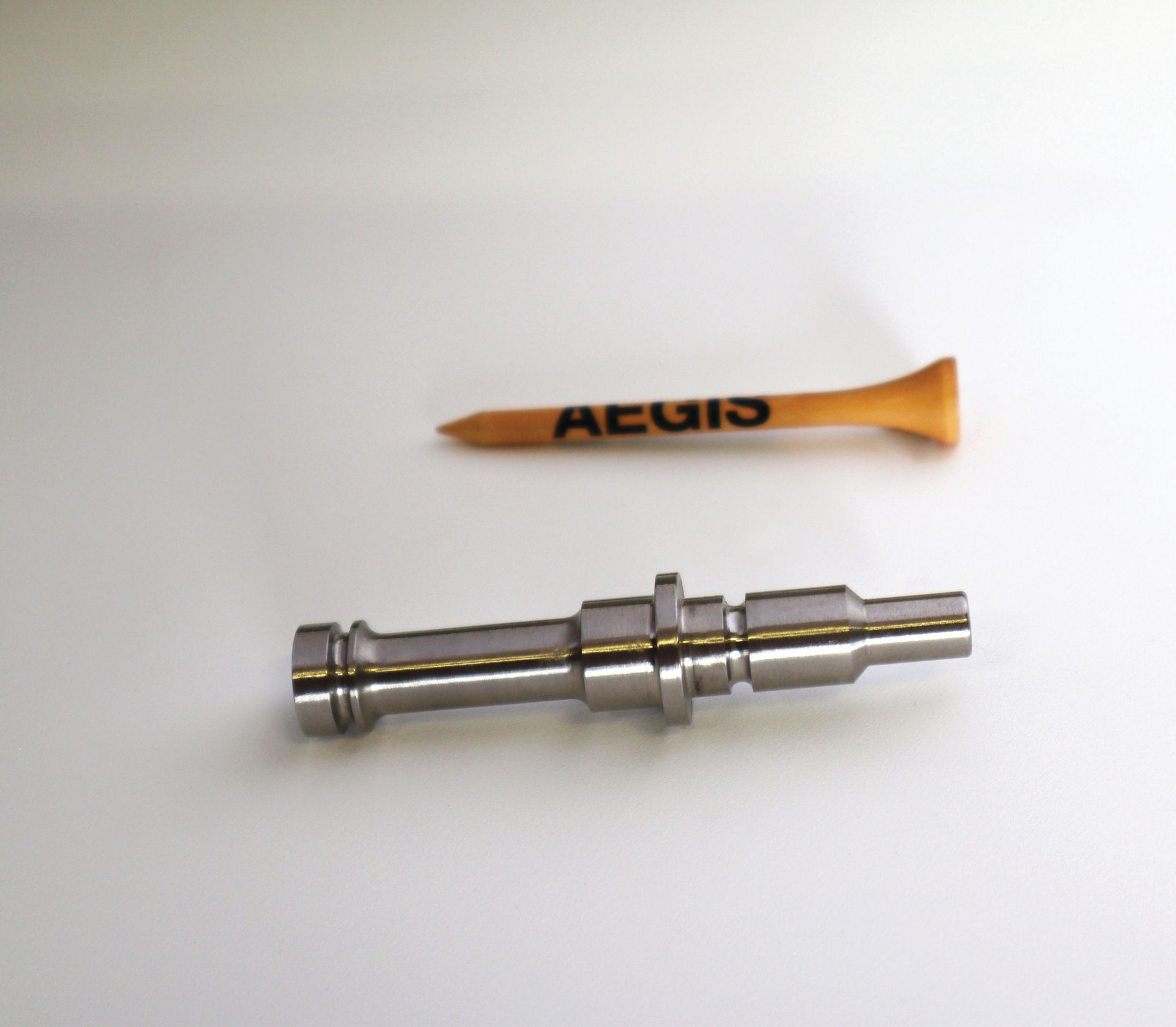 A golf tee with the word acuis on it