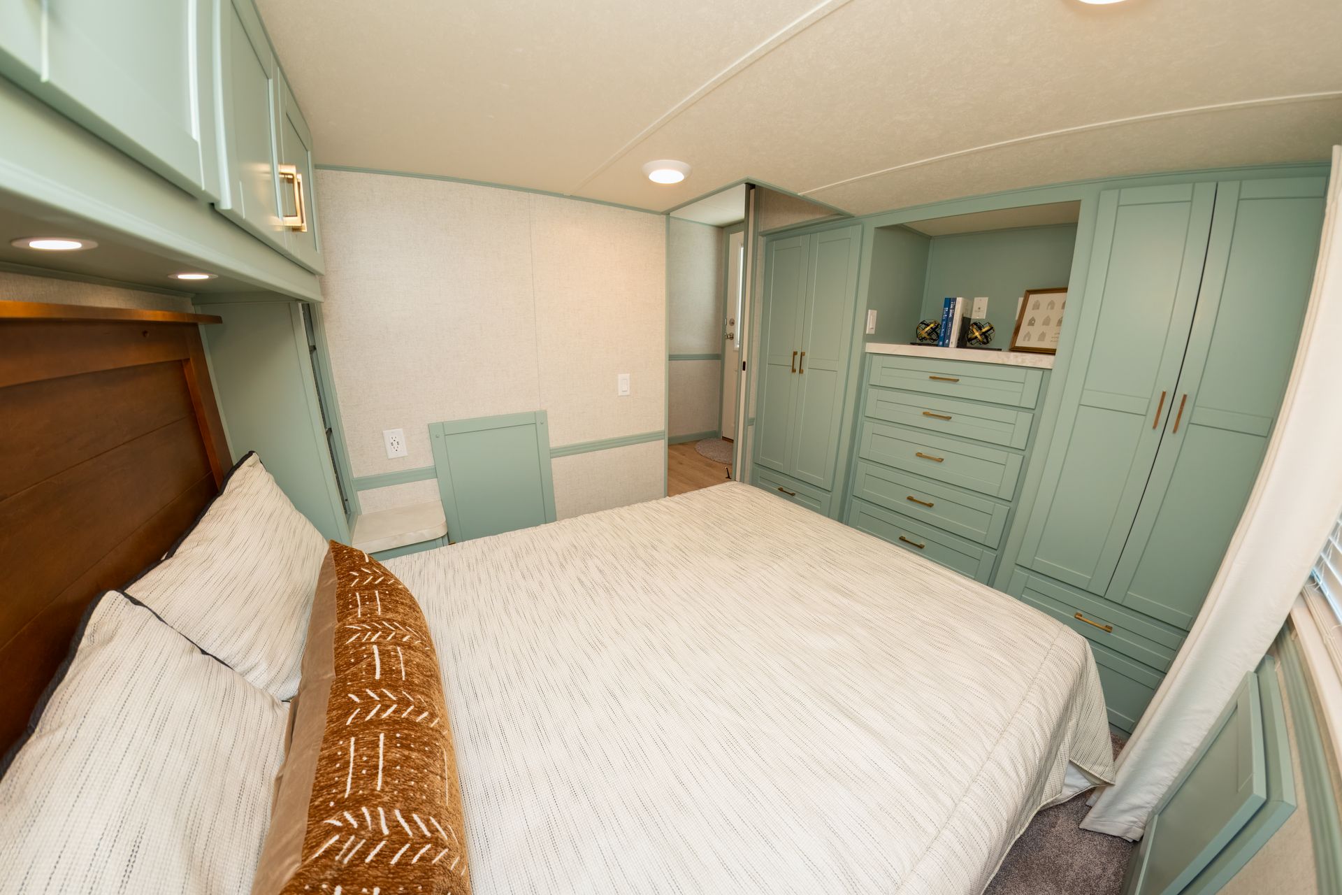 a bedroom with a king size bed , dresser , and cabinets .