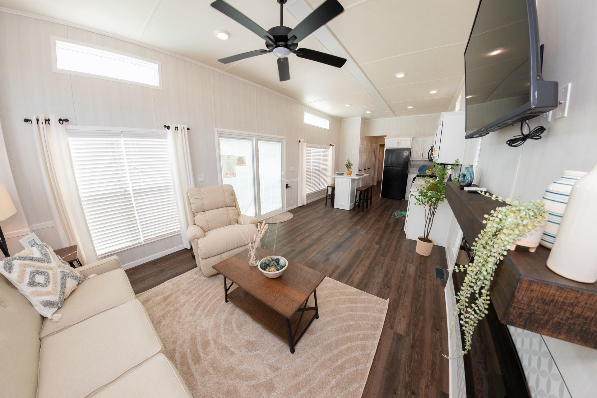 a living room with a couch , chair , coffee table and television .
