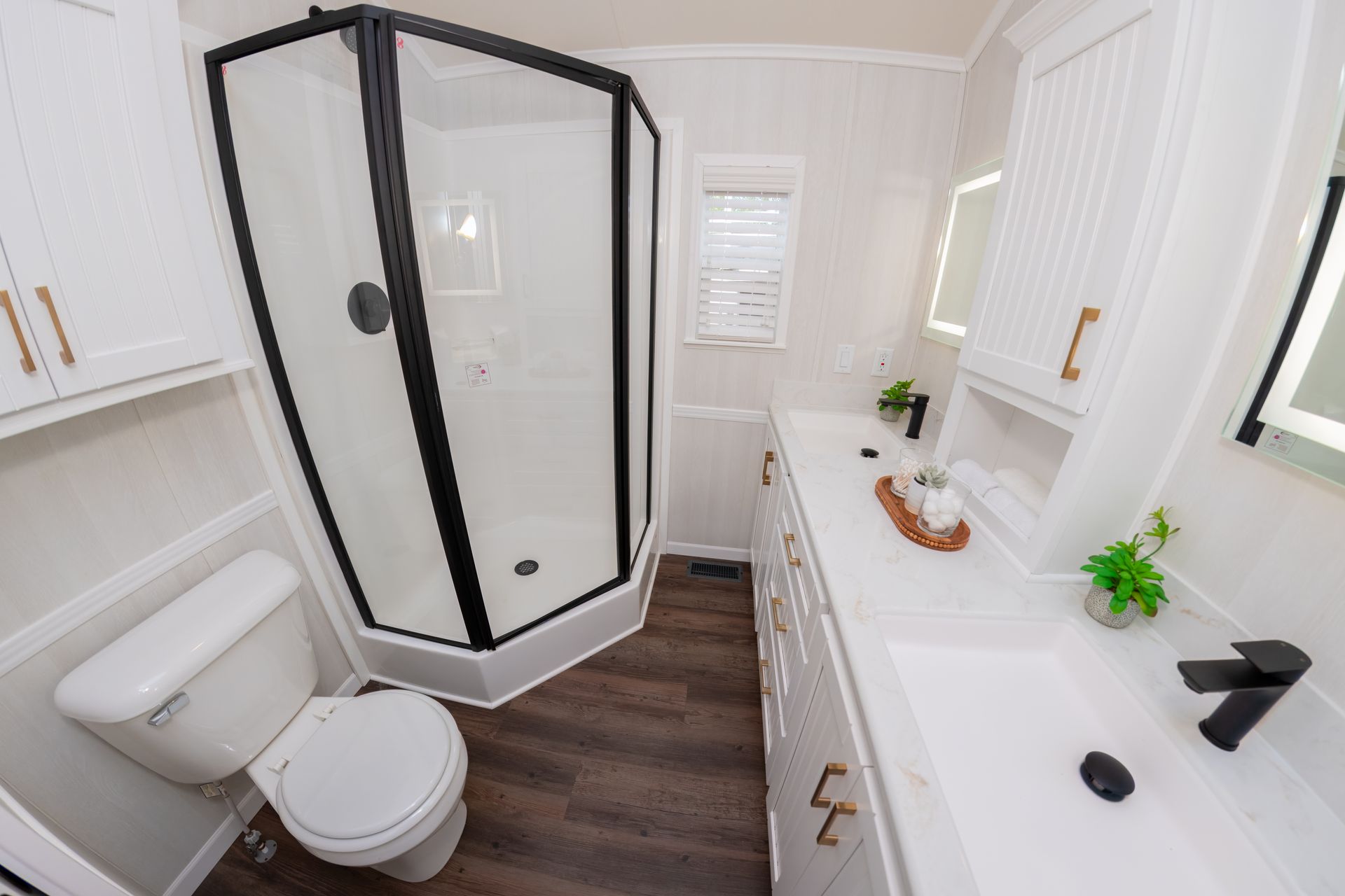 a bathroom with a toilet , sink , shower and mirror .